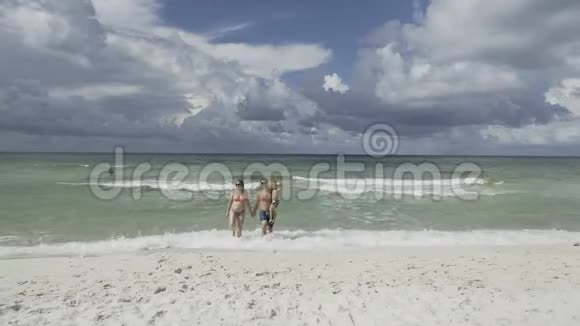 快乐的家庭在沙滩上享受早晨的散步4k视频的预览图
