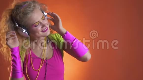 快乐的年轻女子用耳机吹头发听音乐视频的预览图