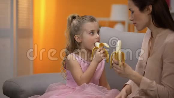 美丽的小公主和妈妈吃香蕉健康的零食营养视频的预览图