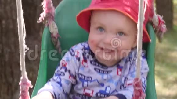 一个满脸蚊虫叮咬的红色巴拿马小男孩正骑在公园的秋千上树上挂着树视频的预览图