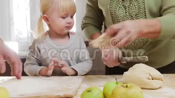 一家人做小馅饼小女孩嚼生面团视频的预览图