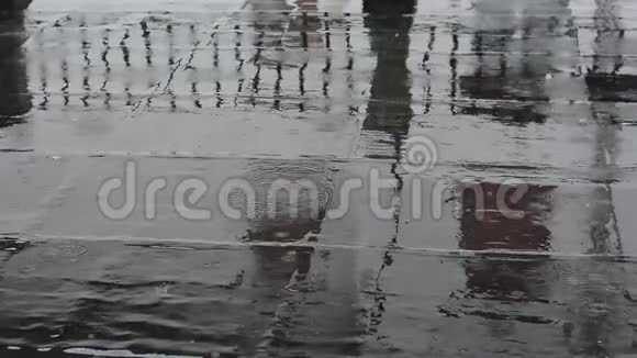 雨点落在黑色的柏油路上视频的预览图