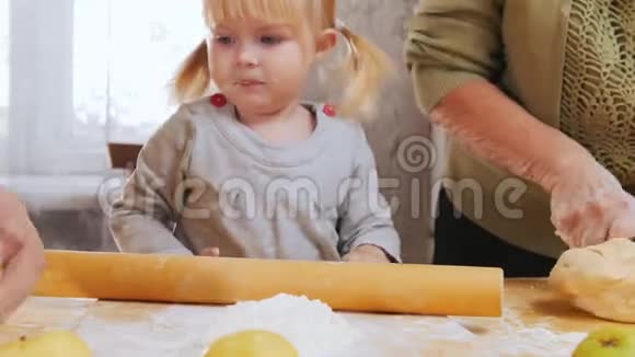 一家人做小馅饼一个小女孩在看这个过程视频的预览图