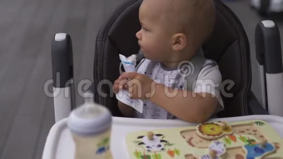 面部特写搞笑白胡子年轻妈妈喂坐在儿童座椅上的男婴儿子家庭价值观温暖视频的预览图