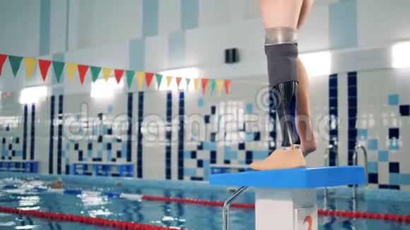 游泳者站在游泳池附近戴着假腿靠近视频的预览图