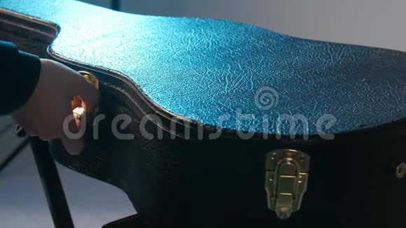乐器的概念一个男人用吉他打开箱子视频的预览图