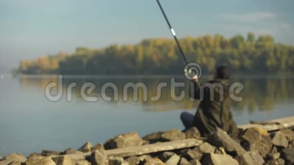 专业渔夫在河岸捕鱼浮标特写钓竿和钓具视频的预览图