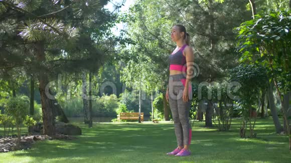 在夏季公园里蹲着的积极健康的女人视频的预览图