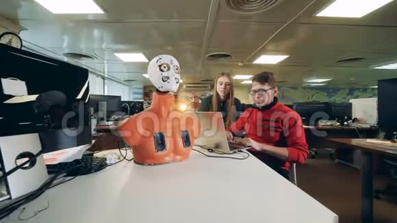 一个实验室里控制机器人的女人和男人关门视频的预览图