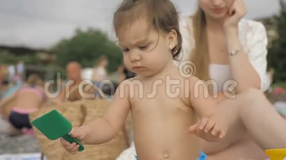 快乐的母女在沙滩上玩石子视频的预览图