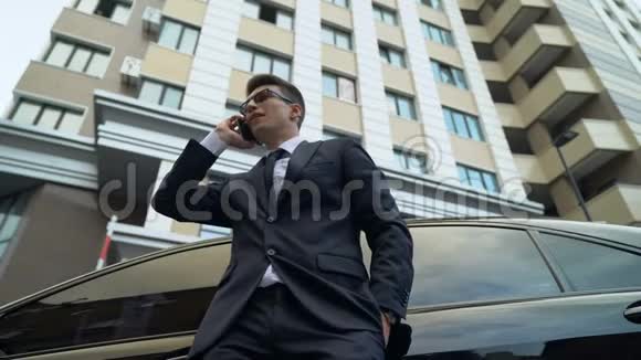 穿西装的男人打电话好消息成功交易公寓大楼视频的预览图