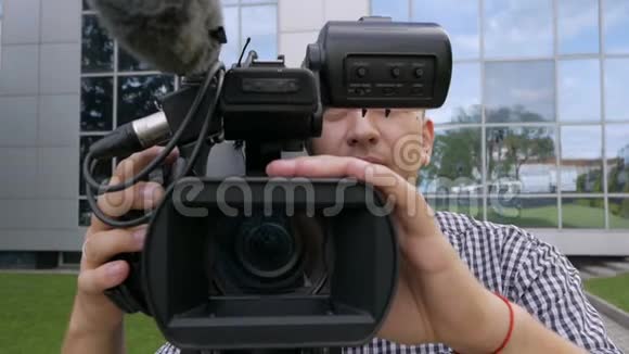 电视操作员用专业的摄像机移除视频摄像机站在三脚架上全景拍摄视频的预览图