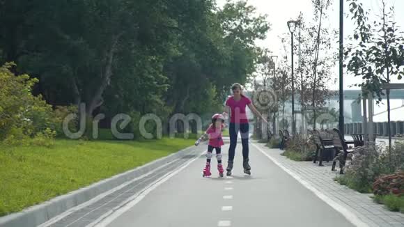 有女儿在公园里溜旱冰的年轻女子视频的预览图