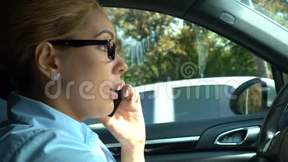 女商人用手机说话坐在司机的车上安全规则视频的预览图