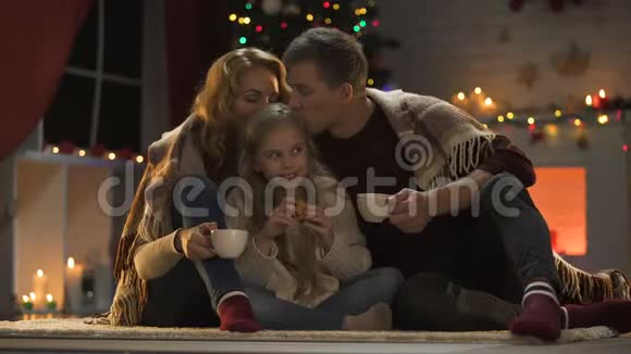 幸福的家庭在闪闪发光的圣诞树旁喝热可可奇迹般的一天视频的预览图