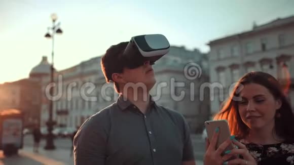 迷人的盖伊和英俊的女孩在城市拥挤的街道上戴着虚拟现实眼镜视频的预览图