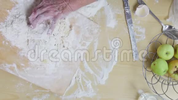 一个做馅饼的老太婆做个面团从桌子上倒面粉视频的预览图