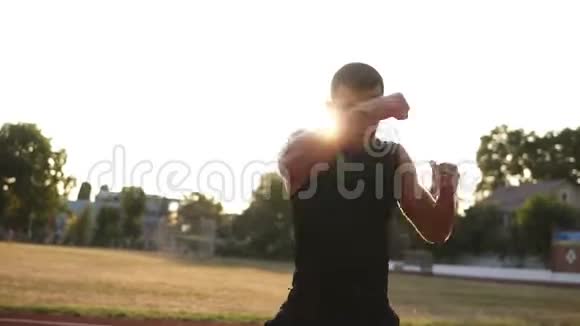 一个活跃愤怒的男拳击手在室外体育场训练过程中的加速镜头人像视频的预览图
