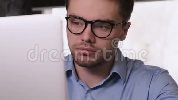 一个戴眼镜的大胡子男人在笔记本电脑上工作视频的预览图