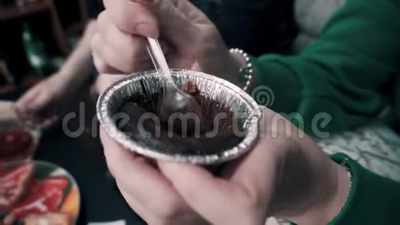 女孩用勺子吃着闪亮杯子里的巧克力蛋糕女孩手的特写镜头美味佳肴视频的预览图