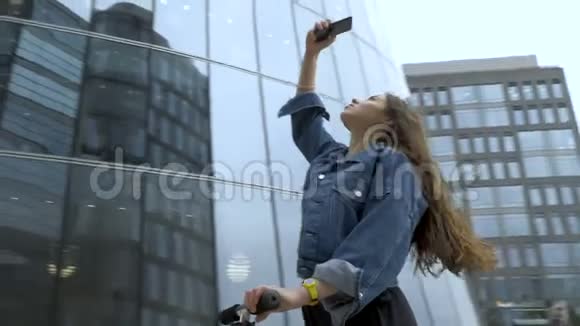 可爱的游客用智能手机相机拍摄未来主义商业中心的照片视频的预览图