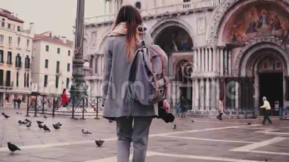 后景时尚女游客背包和相机靠近圣马可大教堂建筑在威尼斯慢动作视频的预览图