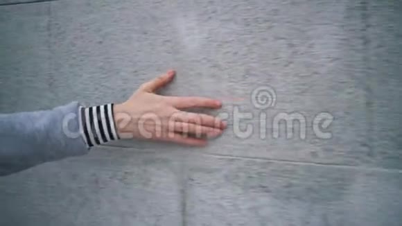 女人的手碰到灰色的墙视频的预览图