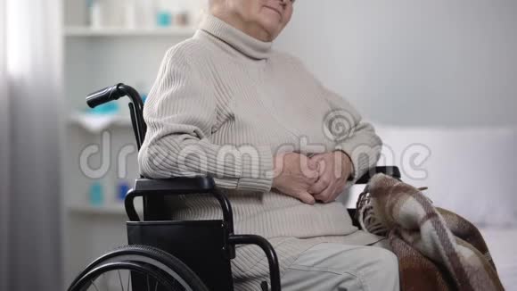 护士用毯子覆盖轮椅上的老妇人照顾病人视频的预览图