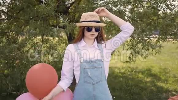戴帽子的开朗的姜女拿着气球把帽子扔在相机上视频的预览图