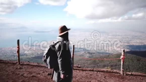 从维苏威火山徒步旅行的年轻美丽女性游客的侧视图欣赏那不勒斯的风景视频的预览图