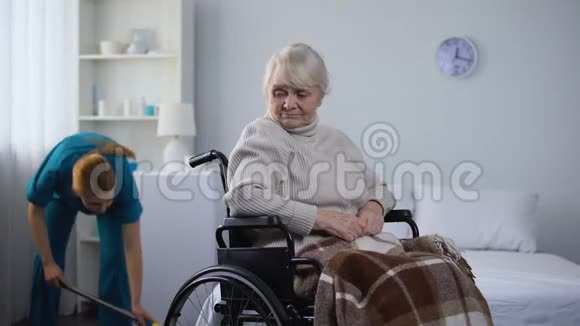 坐在轮椅上的悲伤女人看着医院的清洁室医疗中心视频的预览图