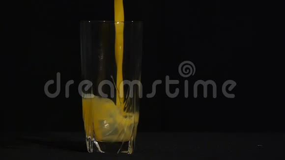 橙汁倒在一个黑色背景的高玻璃里特写镜头有机饮料橙或菠萝汁视频的预览图