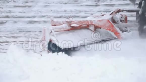 一辆拖拉机的特写用大刷子扫雪从城市的街道视频的预览图