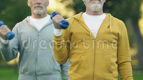 运动的祖父举起哑铃在新鲜空气中抽送肌肉医疗保健视频的预览图