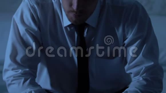 疲惫的男人孤独地坐在卧室里工作过度私人生活问题视频的预览图