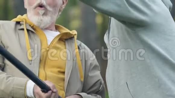 大胡子帮他的退休朋友把鱼从水里捞出来这是男性的爱好视频的预览图