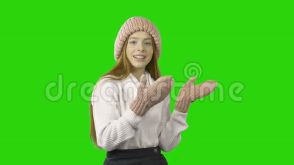 一个身穿粉色针织帽子和针织粉色手套的年轻红发少女用微笑和微笑来表达情感视频的预览图