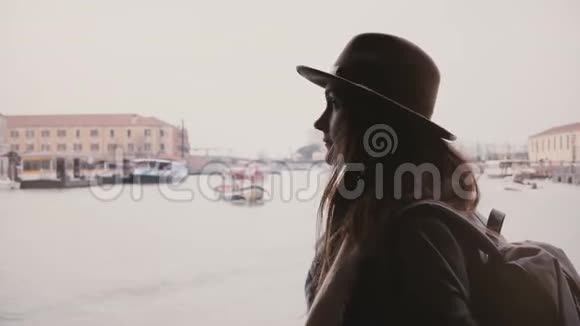 意大利威尼斯冬日年轻迷人的女游客在繁忙的城市河畔乘船游览美丽的风景视频的预览图