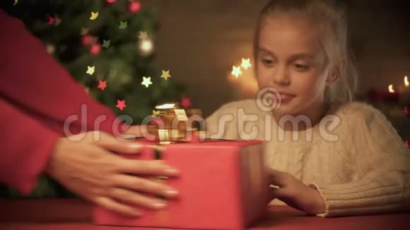 女士送给兴奋的女孩圣诞礼物节日快乐树闪闪发光视频的预览图