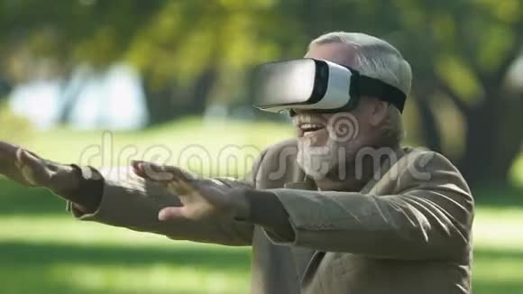 虚拟现实耳机中的老人玩模拟游戏现代科技视频的预览图