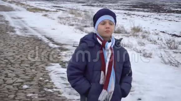 男孩走在结冰的路上视频的预览图
