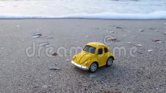 旅行和度假玩具黄车在沙滩上靠海视频的预览图