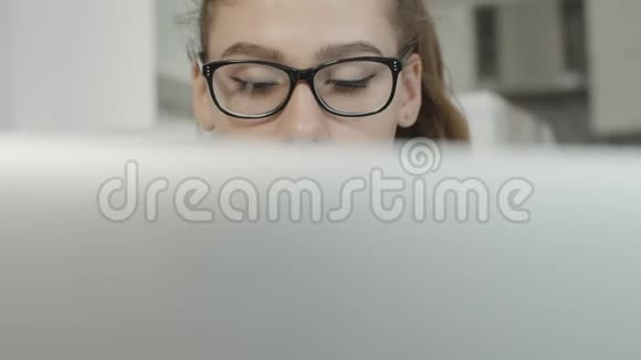 疲惫的女孩看着笔记本上的文字看着笔记本屏幕准备考试视频的预览图