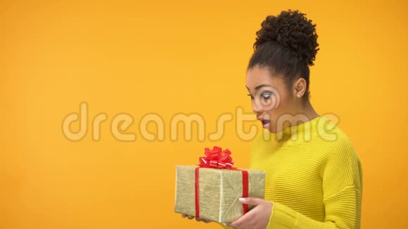 惊喜的黑女人拿着生日礼物盒意外的礼物背景视频的预览图