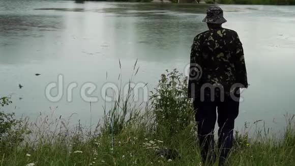 渔夫站在湖边雨中飞翔的鸟儿视频的预览图