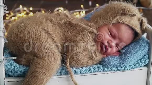新生婴儿穿着棕色服装睡在照片区视频的预览图