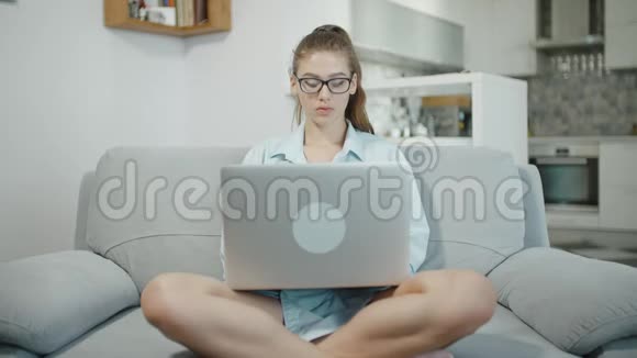十几岁的女孩在家里用笔记本电脑在笔记本上打字心烦意乱准备考试视频的预览图