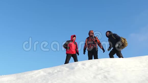 旅行者来到一座雪山的山顶享受对抗蓝天的胜利团队合作和胜利团队合作视频的预览图