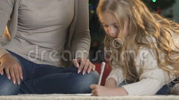 可爱的母亲帮助小女儿写信给圣诞老人童年视频的预览图
