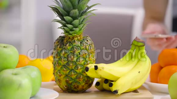无法辨认的人在水果桌上拍摄一个菠萝视频的预览图
